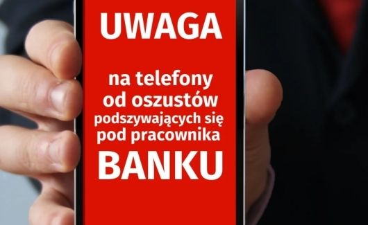 Telefon z napisem na ekranie: Uwaga na telefony od oszustów podszywających się pod pracownika banku