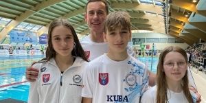 Trójka dzieci, zawodników w pływaniu i trener