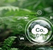 Grafika z chmurką - w niej symbol CO2 - obok różne symbole ekologiczne